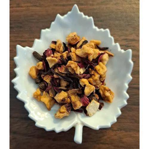 Apple Chai  in a white leaf-shaped bowl on a wooden surface