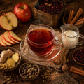 Apple Chai - Tea cup with steam, apples, spices, and milk on a wooden surface