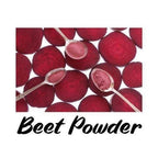 Beets with spoons containing beet powder on a white background