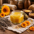 Jar of Calendula Salve on a wooden surface with calendula, sunflowers and lavender.