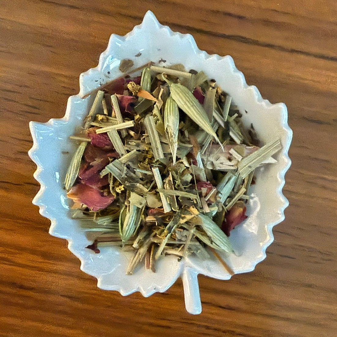 Detox & Cleanse herbal mix in a white decorative bowl on a wooden surface