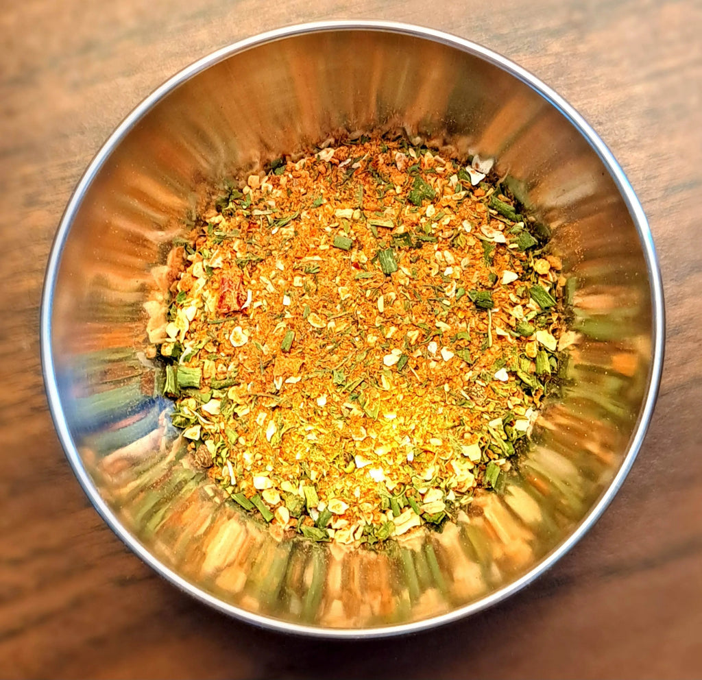 Metallic bowl filled with Farmhouse Dressing spice mix on a wooden surface