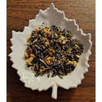Good Night herbal blend on a white leaf shaped ceramic dish on a wooden surface