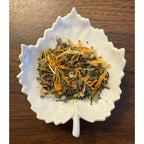 Healthy Liver herbal blend on a white leaf shaped ceramic dish on a wooden surface