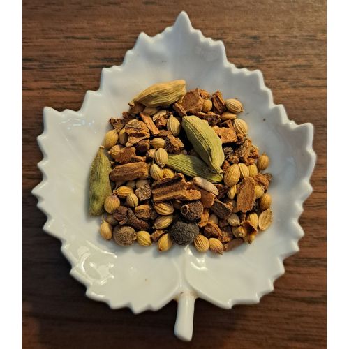 Herbal Chai blend on a white leaf shaped ceramic dish on a wooden surface