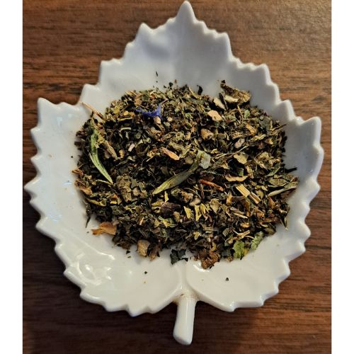 Immune Support herbal blend on a white leaf shaped ceramic dish on a wooden surface