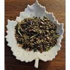 Immune Support herbal blend on a white leaf shaped ceramic dish on a wooden surface