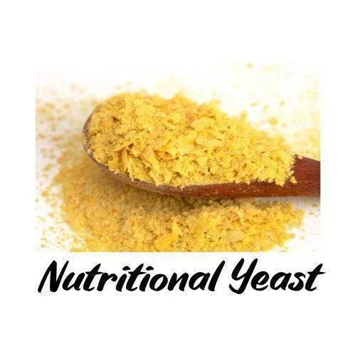Nutritional yeast on a wooden spoon with text overlay on a white background