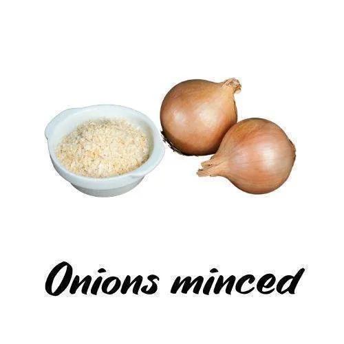Minced onions in a bowl with whole onions on a white background
