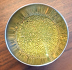 Metallic bowl with Poultry Seasoning on a wooden surface