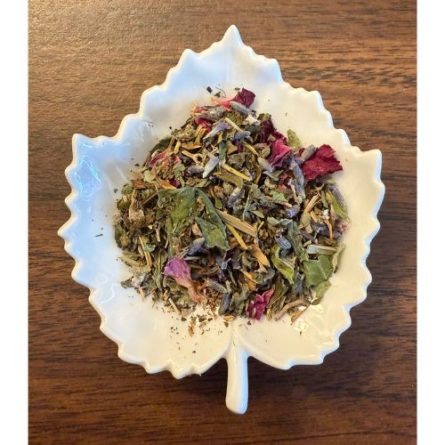 Teacher Fuel herbal blend on a white leaf shaped ceramic dish on a wooden surface